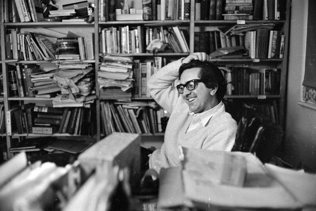 Photo of author Len Deighton surrounded by books